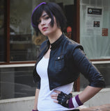 Person wearing a purple and white wristband with fingerless gloves