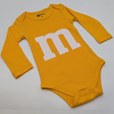 M&M print baby onesie flat lay