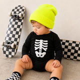 Black baby bodysuit with white skeleton print styled with a neon beanie and checkered socks