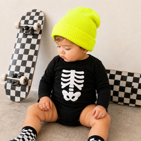 Black baby bodysuit with white skeleton print styled with a neon beanie and checkered socks